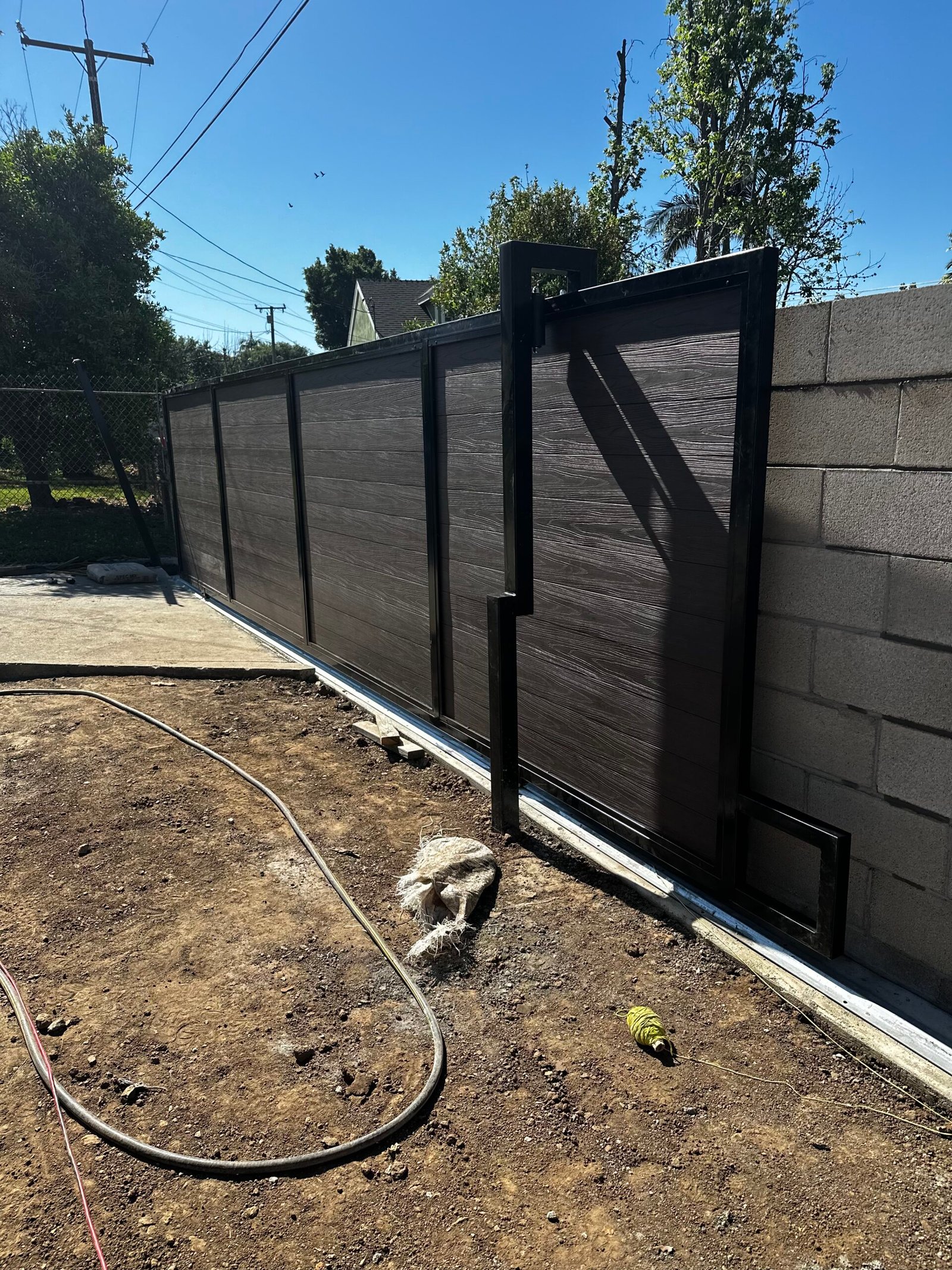 Custom driveway gate and decorative iron metalwork installation by Elite Hardscape Inc.