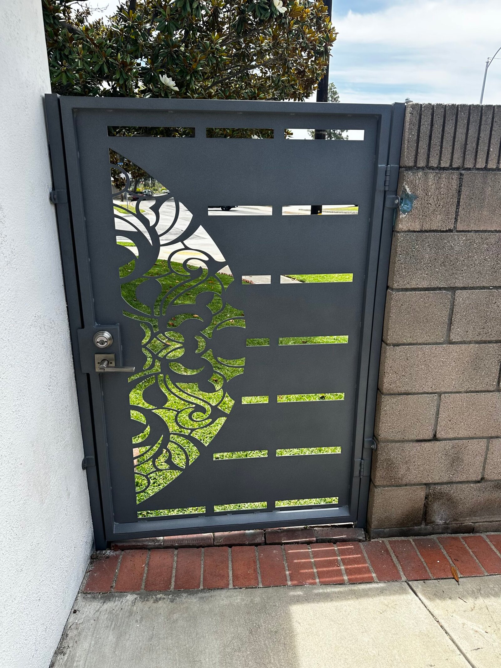 Custom welded iron entry gate fabricated and installed by Elite Hardscape Inc.